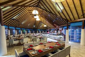 Innenansicht des Restaurants des Amaya Kuda Rah Hotels mit gedeckten Tischen und Stühlen.