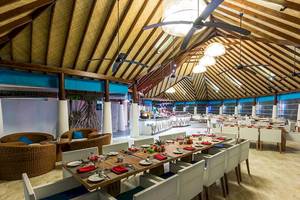 Innenbereich des Amaya Kuda Rah Restaurants mit langen Tischen und Stühlen.