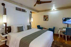 Hotelzimmer von Amaya Kuda Rah mit Doppelbett, Fernseher, und Arbeitsbereich.