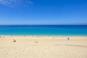 Strand am Sol Fuerteventura Jandia Hotel mit blauem Ozean und vielen Menschen.
