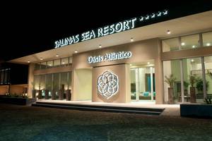 Außenansicht des Oasis Salinas Sea Resort mit Beleuchtung und Logo in der Nacht