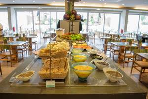 Frühstücksbuffet im Oasis Salinas Sea Hotel mit Brot, Obst und verschiedenen Gerichten.