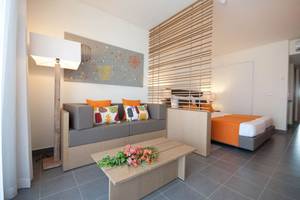 Innenansicht eines Zimmers im Oasis Salinas Sea Hotel mit einem Sofa, Tisch und Bett.