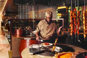Koch im Al Ain Rotana Hotel, der im Restaurant würzige Fleischspieße grillt.