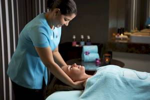 Eine Frau genießt eine Massagebehandlung im Al Ain Rotana Hotel.