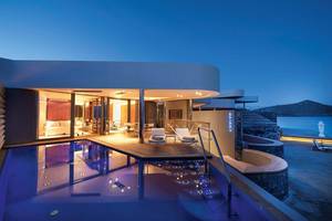 Nachtansicht des Elounda Beach Hotel & Villas mit beleuchtetem Pool und Außenbereich.