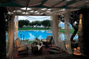 Terrasse im Elounda Beach Hotel & Villas mit Blick auf den Pool und die Landschaft.