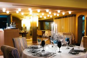Ein gedeckter Tisch im Elounda Beach Hotel & Villas Restaurant mit Kerzen und Geschirr.