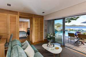 Innenansicht einer Suite im Elounda Beach Hotel & Villas mit Blick auf einen Pool.