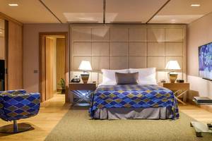 Schlafzimmer im Elounda Beach Hotel & Villas mit Doppelbett und Nachttischen.