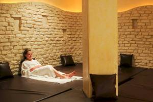 Eine Frau liegt in einem weißen Handtuch auf einer Liege in einem Spa-Bereich des Djerba Resorts.