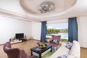 Innenansicht des Wohnzimmers im Pickalbatros Aqua Blu Resort mit moderner Einrichtung und Blick auf den Pool.