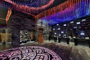 Lobby des W Muscat Hotels mit leuchtenden Lampen und Marmorboden.