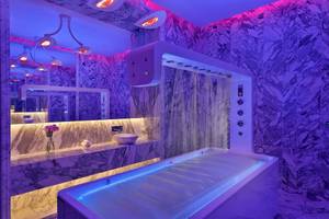 Modernes Badezimmer mit violetten LED-Lichtern und Marmorwänden im W Muscat Hotel.