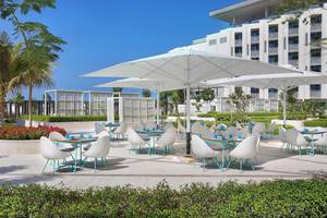 Außenbereich des W Muscat Hotels mit Essbereich und Terrassenmöbeln.