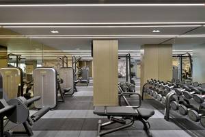 Fitnesscenter im W Muscat Hotel mit verschiedenen Trainingsgeräten und Spiegeln.