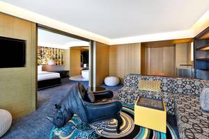 Innenansicht der Suite im W Muscat Hotel mit afrikanischem Rhino-Dekor, modernen Möbeln und offenem Badezimmerbereich.