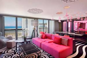 W Muscat Hotel Innenraum mit rosa Sofa und schwarzem Teppich