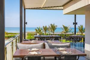 Terrasse des W Muscat Hotels mit Blick auf das Meer und Palmen