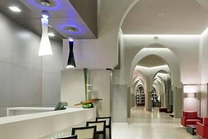Empfangsbereich des Barcelo Palmeraie Hotels mit roten Sesseln und moderner Architektur.