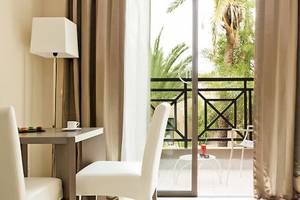 Zimmer im Barcelo Palmeraie Hotel mit Blick auf einen Balkon und Außenbereich.