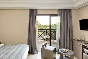 Hotelzimmer im Barcelo Palmeraie Hotel mit Balkon und Ausblick auf den Garten.