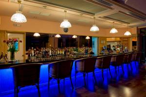 Foto von Sitzplätzen mit blauer Beleuchtung an der Bar im Puerto Palace Hotel.