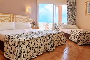 Doppelzimmer im Puerto Palace Hotel mit Blick auf den Balkon und Meer.