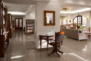 Innenansicht der Lobby des Almyrida Beach Hotels mit Bücherregal, Tisch und Sofa.