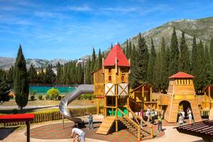 Spielplatz im Freien im Remisens Hotel Albatros mit Holzburgen und Rutsche