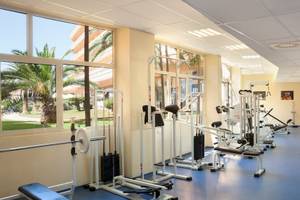 Fitnesscenter im Remisens Hotel Albatros mit verschiedenen Trainingsgeräten und großen Fenstern.