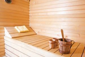 Saunaraum im Remisens Hotel Albatros mit Holzbänken, Handtüchern und Holzeimern.
