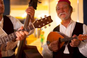 Drei Musiker spielen im Remisens Hotel Albatros Gitarre, Bass und Mandoline.