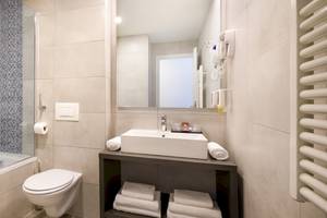 Badezimmer im Remisens Hotel Albatros mit Badewanne, Toilette, Waschbecken und Handtüchern.