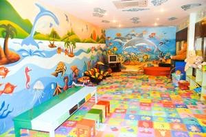 Ein Kinderzimmer mit farbenfroher Wandgestaltung, die Meeresleben darstellt.