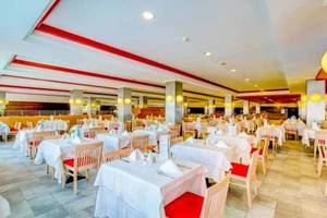Restaurant im SBH Taro Beach Hotel mit vielen gedeckten Tischen und Stühlen.