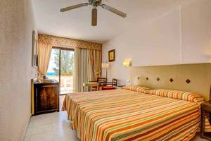 Innenansicht eines Doppelzimmers im SBH Taro Beach Hotel mit Bett, Nachttischen und Aussicht.