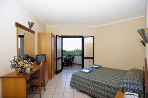 Hotelzimmer mit Balkon, Bett, Schreibtisch und Fernseher.
