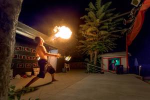 Feuershow im Freien am Olympic Palace Resort mit einem Mann, der Feuer spuckt.