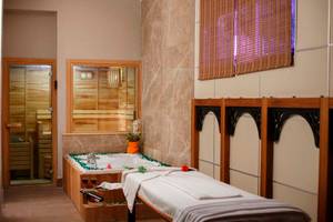 Spa-Behandlungsraum im Side Crown Palace mit Jacuzzi und Massageliege.