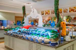 Buffet-Tisch im Side Crown Palace Hotel mit verschiedenen Speisen in weißen Schalen und Dekorationen.