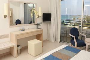 Vrissiana Beach Hotelzimmer mit Meerblick, Spiegel, Fernseher und Balkon.