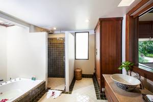 Badezimmer im The Fair House Beach Resort mit Badewanne, Dusche und Waschbecken.