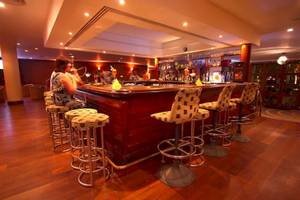 Bar des Occidental Eden Beruwala Hotels mit rauchender Frau und Cocktails.