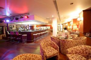 Innenansicht der Bar des Occidental Eden Beruwala mit gepolsterten Stühlen und einer Theke.