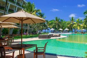 Außenansicht des Pools im Occidental Eden Beruwala Hotel mit Sonnenschirmen, Tischen und Stühlen.