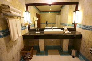 Badezimmer im Occidental Eden Beruwala Hotel mit weißem Waschbecken und Marmorfliesen.