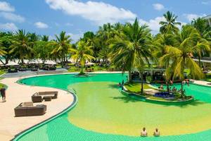 Außenansicht des Occidental Eden Beruwala Resorts mit Swimmingpool, Palmen und Hotelgebäuden.