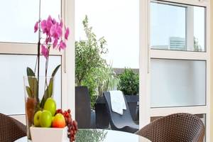 NH Hamburg Altona Hotel Innenraum mit Terrassenmöbeln und Obstschüssel