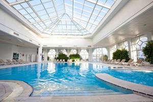 Innenpool des El Mouradi Hammamet Hotels mit Glasdach und Loungeliegen